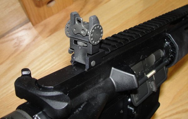 The rear sight folds down just before the charging handle. Notice the adjustable apertures.