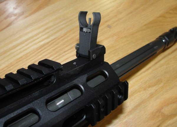 The IRS system has slots for the sights to fold down flush with the top rail.