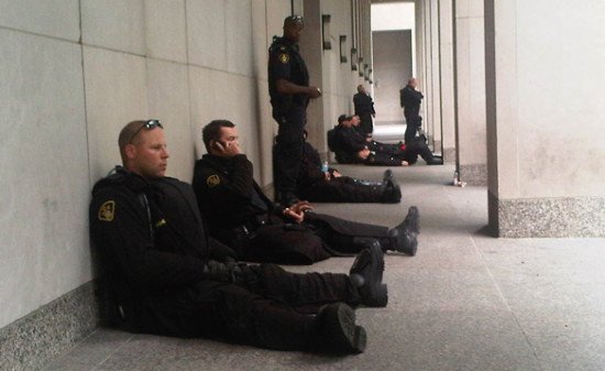 Even during protests and civil unrest, cops can become bored and complacent. (Photo - Canadian Broadcasting Corporation)