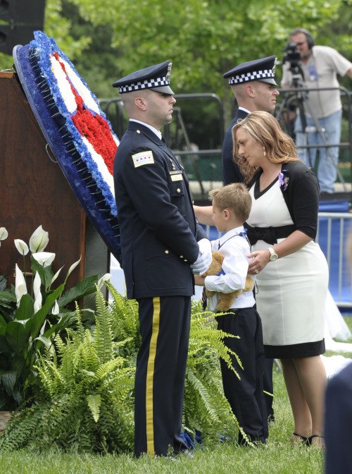 A surviving wife and son pay homage, while two police honor guards stand watch for the fallen