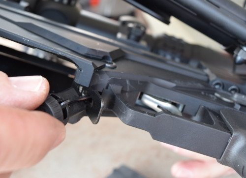 Adjusting the Ruger Precision Rifle trigger weight. The specific tool screws into the rear of the buffer tube for easy storage.