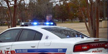A Baton Rouge officer standing outside his patrol cruiser photo by brgov.com).