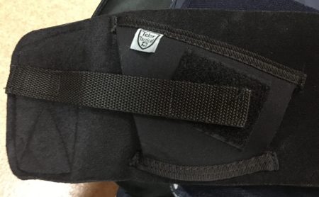 The retention strap attaches to a Velcro patch on the back of the holster but then just to the felt-like material on the outside of the backing.