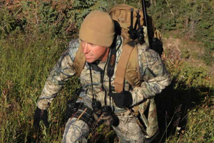 Hunter Packing a Scoped Rifle into the Woods