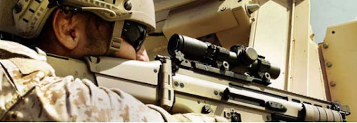 Soldier shooting SCAR rifle with 1-4x scope